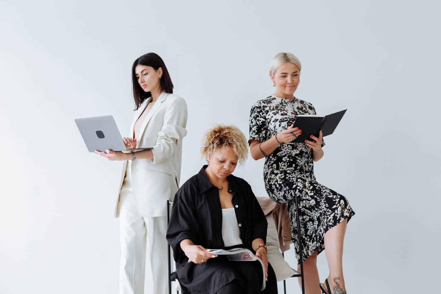 Women working with laptops and tablets in a professional setting.