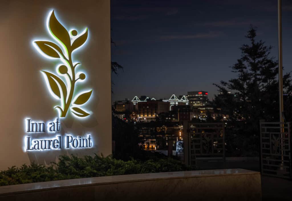 Sign for Inn at Laurel Point illuminated at night.