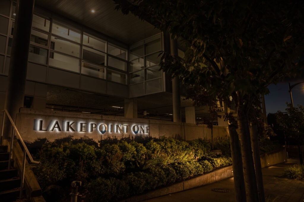 Sign for Lake Point One building in Victoria at night.