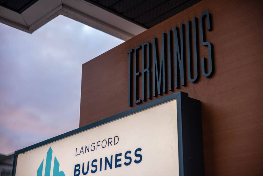 Custom business sign with "Terminus" lettering on building exterior.
