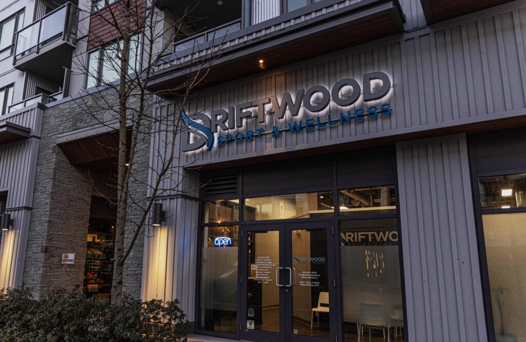 Exterior view of Driftwood Sport & Wellness sign on building facade.