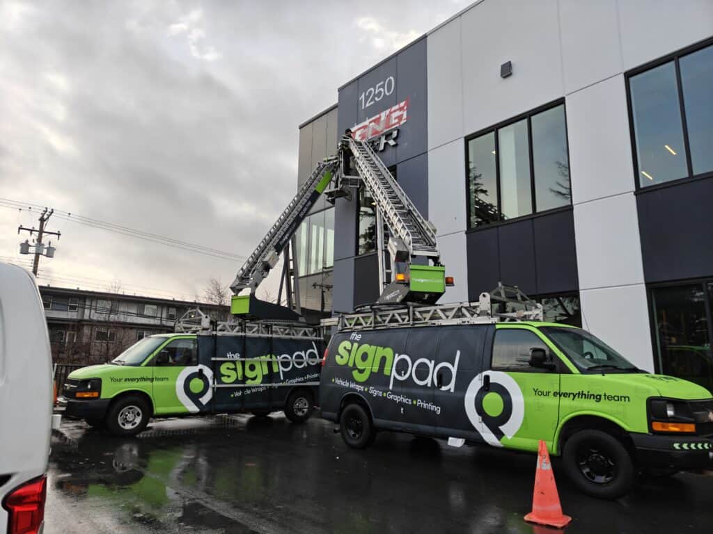 Sign Pad vehicle wrap with ladder truck for sign installation.
