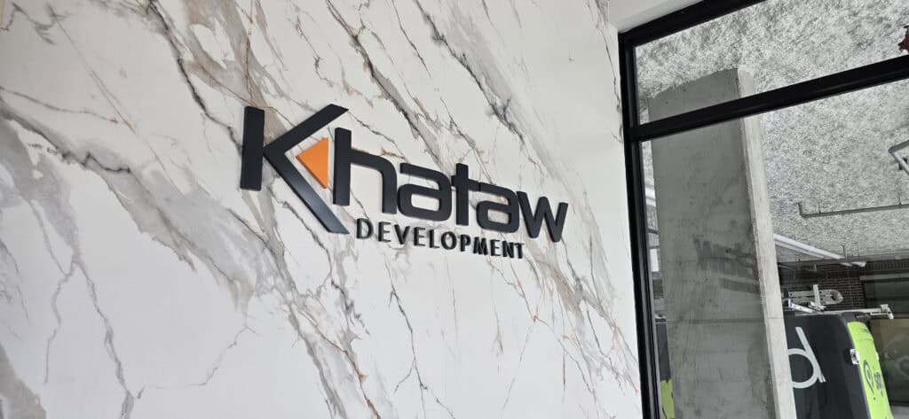 Custom sign reading "Khataw Development" on a marble wall in Victoria.