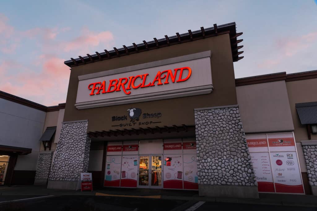 Bright red "Fabricland" sign on building exterior.