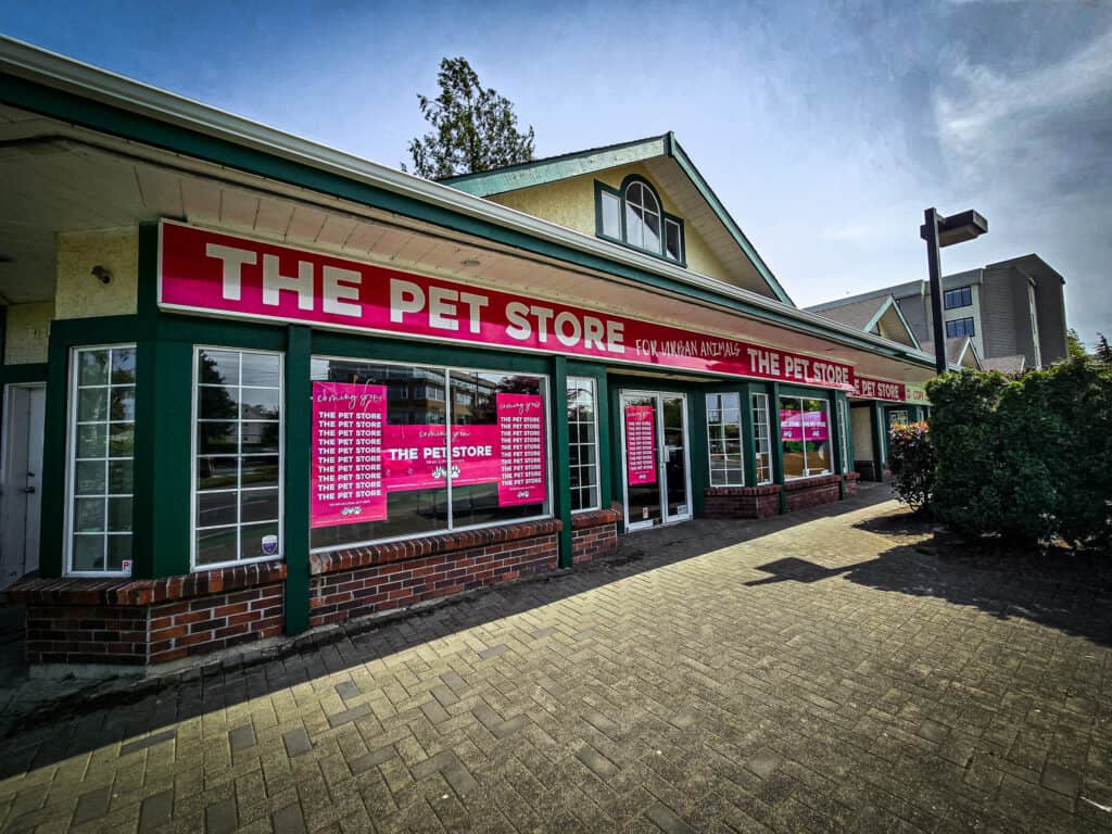 Signage for The Pet Store featuring vibrant pink branding and custom graphics.