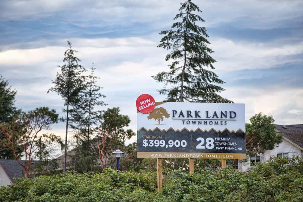 Sign advertising Park Land Townhomes with pricing and website details.