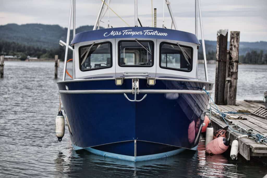 Custom boat sign on a blue vessel docked at the pier.