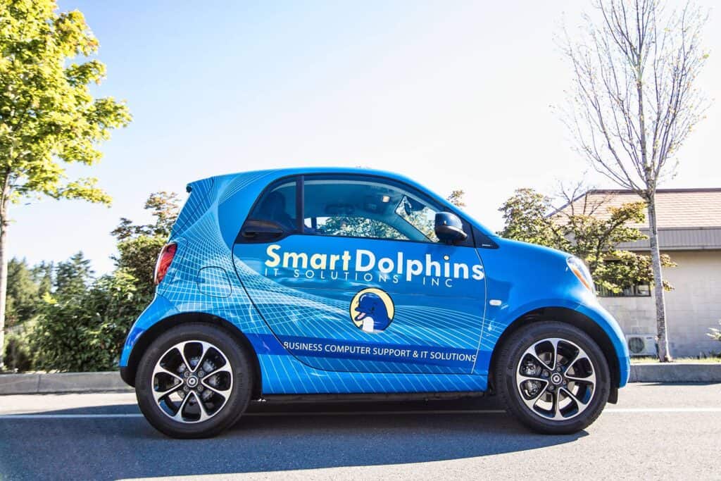 Custom blue vehicle wrap for Smart Dolphins Inc. on a compact car.