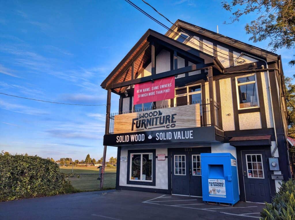 Custom wooden sign for furniture store on building exterior.