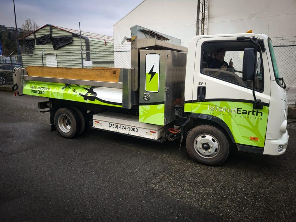 Electric vehicle service truck with custom signage for Island of Earth in Victoria.