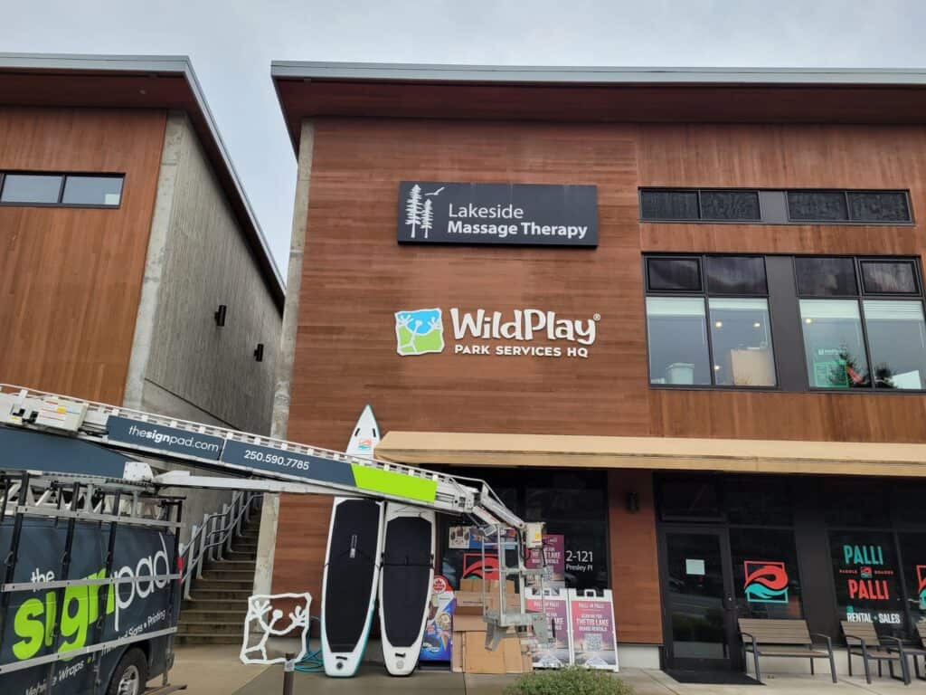 Signage for Lakeside Massage Therapy and WildPlay Dark Services HQ on building facade.