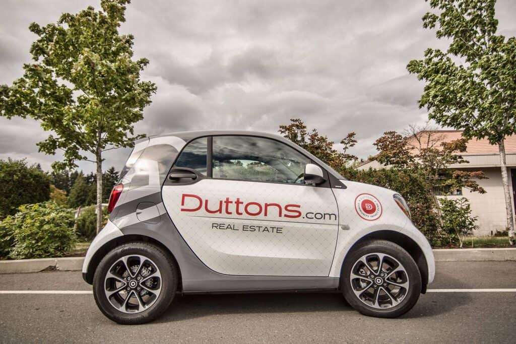 Compact car featuring custom Duttons Real Estate vehicle wrap in Victoria.