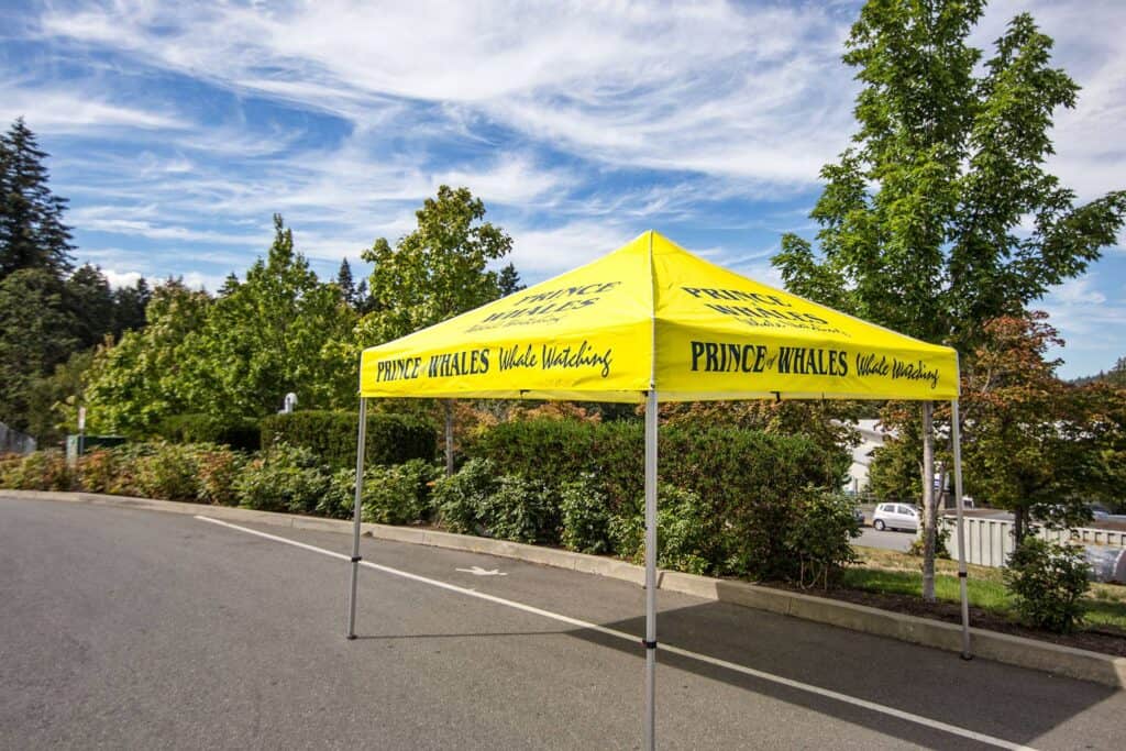 Custom yellow market umbrella with "Prince Whales" branding in Victoria.