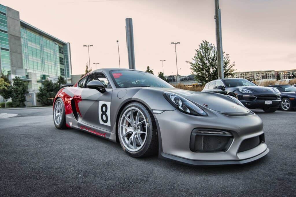 Custom vehicle wrap on sleek sports car in a parking lot.
