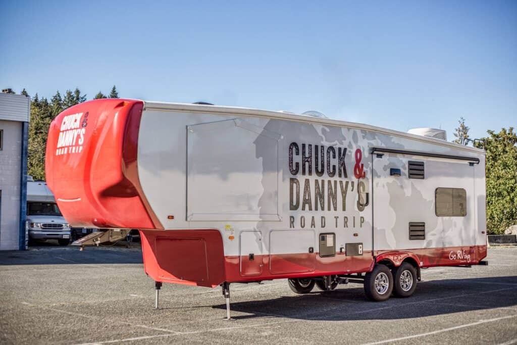 Custom RV sign featuring "Chuck & Danny's Road Trip" for vehicle branding.