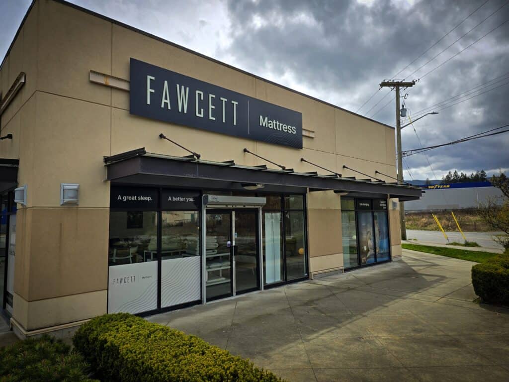 Exterior view of Fawcett Mattress store sign on building facade.