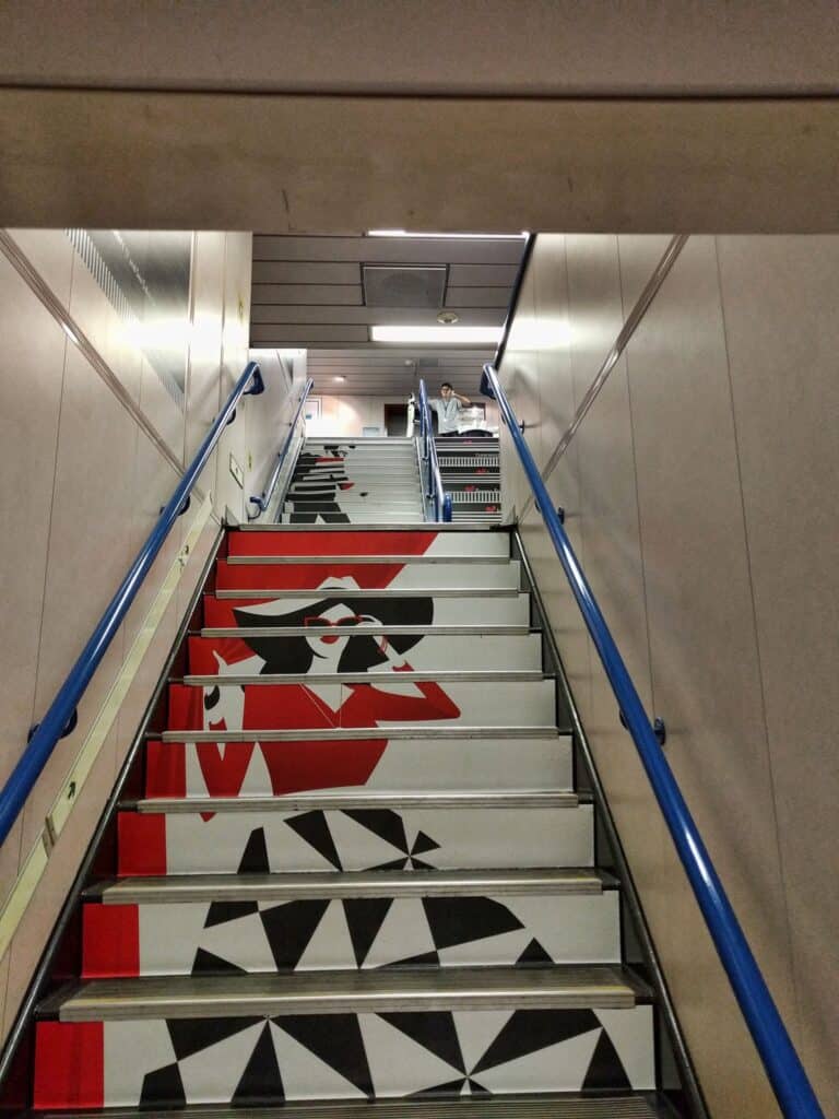 Artistic black, white, and red graphic design on staircase steps.