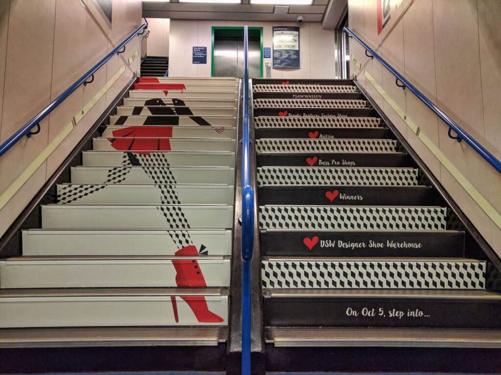 Custom stair decals with a red high heel shoe design and directional signage.