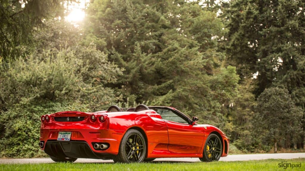 Red sports car with sleek design and black wheels parked outdoors.