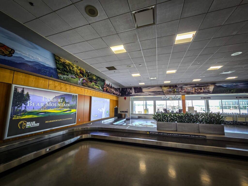 Modern sign pad display at Victoria Airport with scenic landscape visuals.