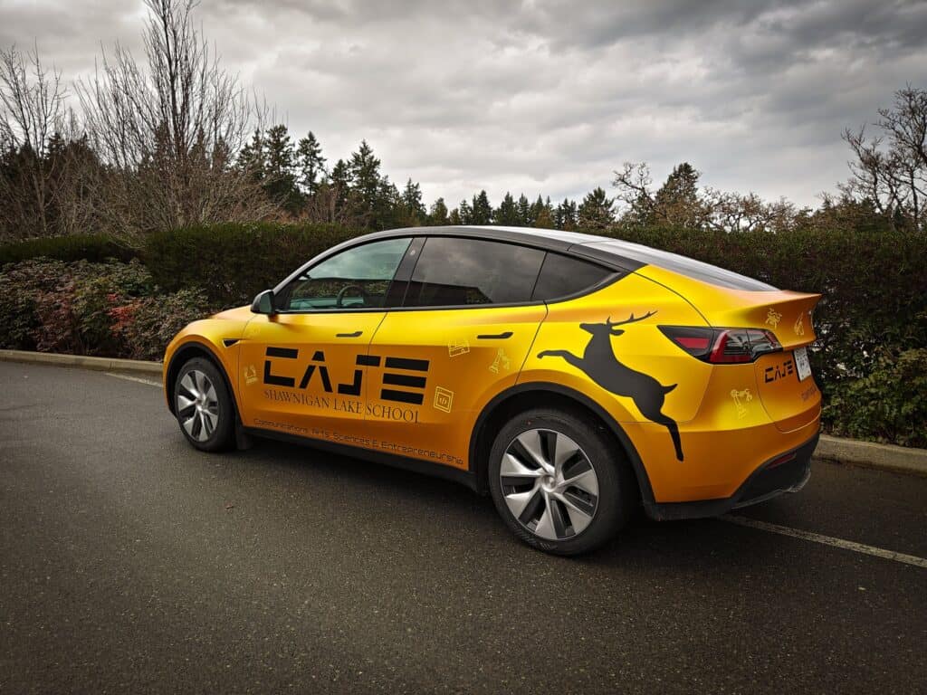 Vehicle wrap with school branding and a jumping kangaroo graphic.