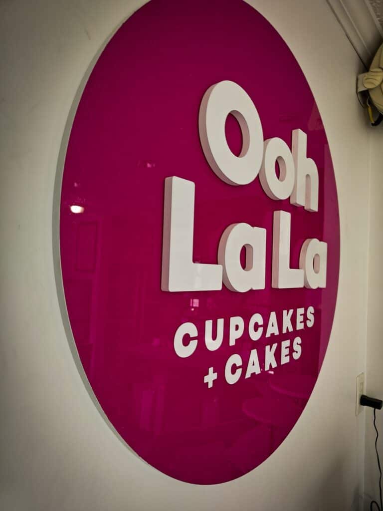 Ooh La La Cupcakes sign with bold white lettering on a pink background.