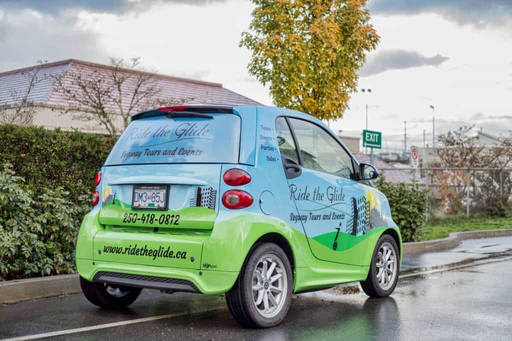 Custom vehicle wrap for Ride the Glide tour car in Victoria, featuring green and blue design.