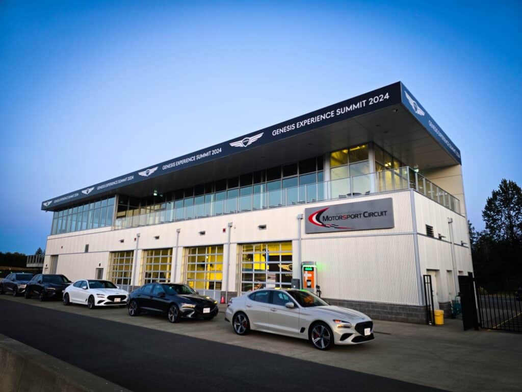 Genesis Experience Summit 2024 building exterior with cars parked in front.