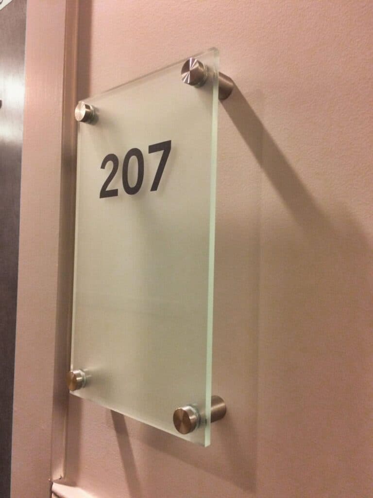 Sign with room number 207 on glass panel.