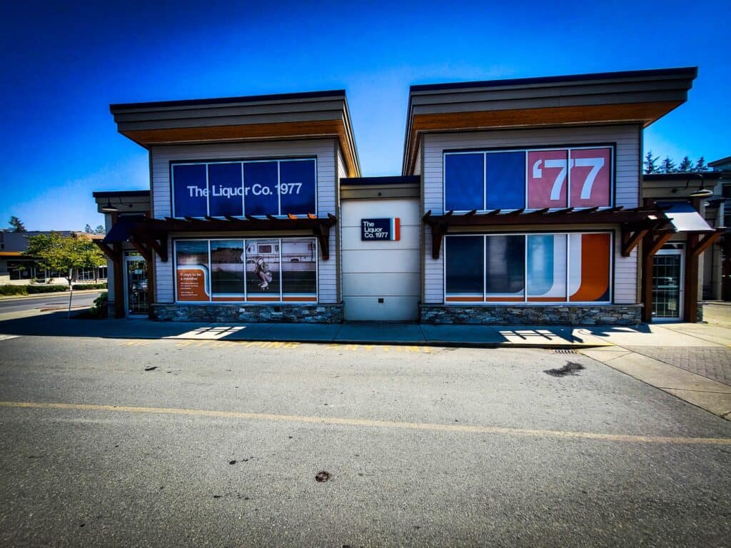 Modern commercial building with vibrant signs and vehicle wraps in Victoria.