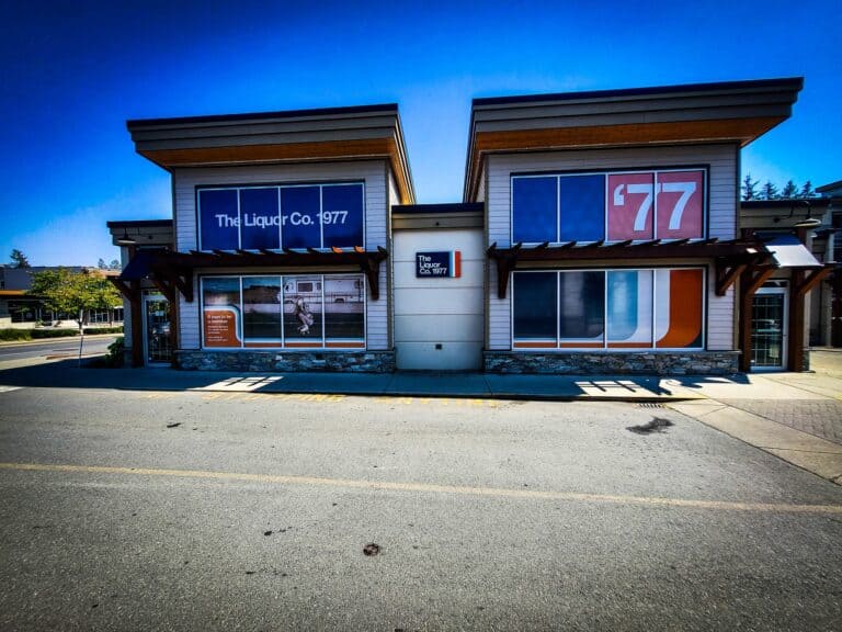 Modern commercial building with vibrant signs and vehicle wraps in Victoria.