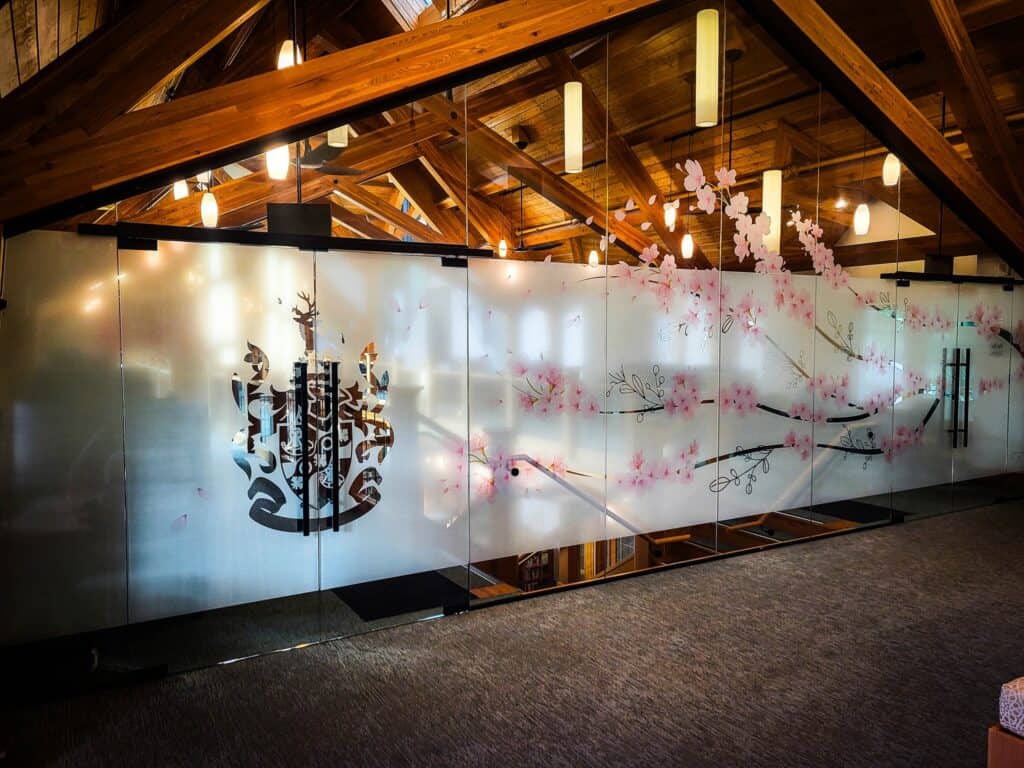 Custom sign with cherry blossom artwork and frosted glass background.