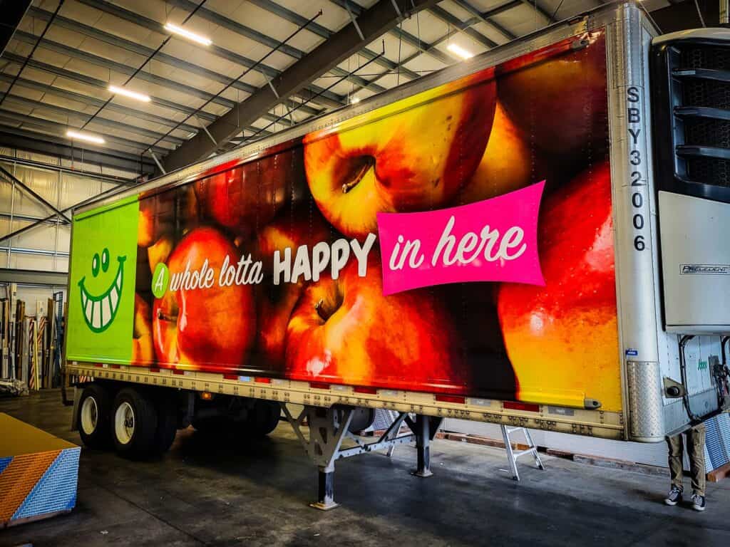 Custom fruit-themed vehicle wrap with vibrant apples and cheerful graphics.