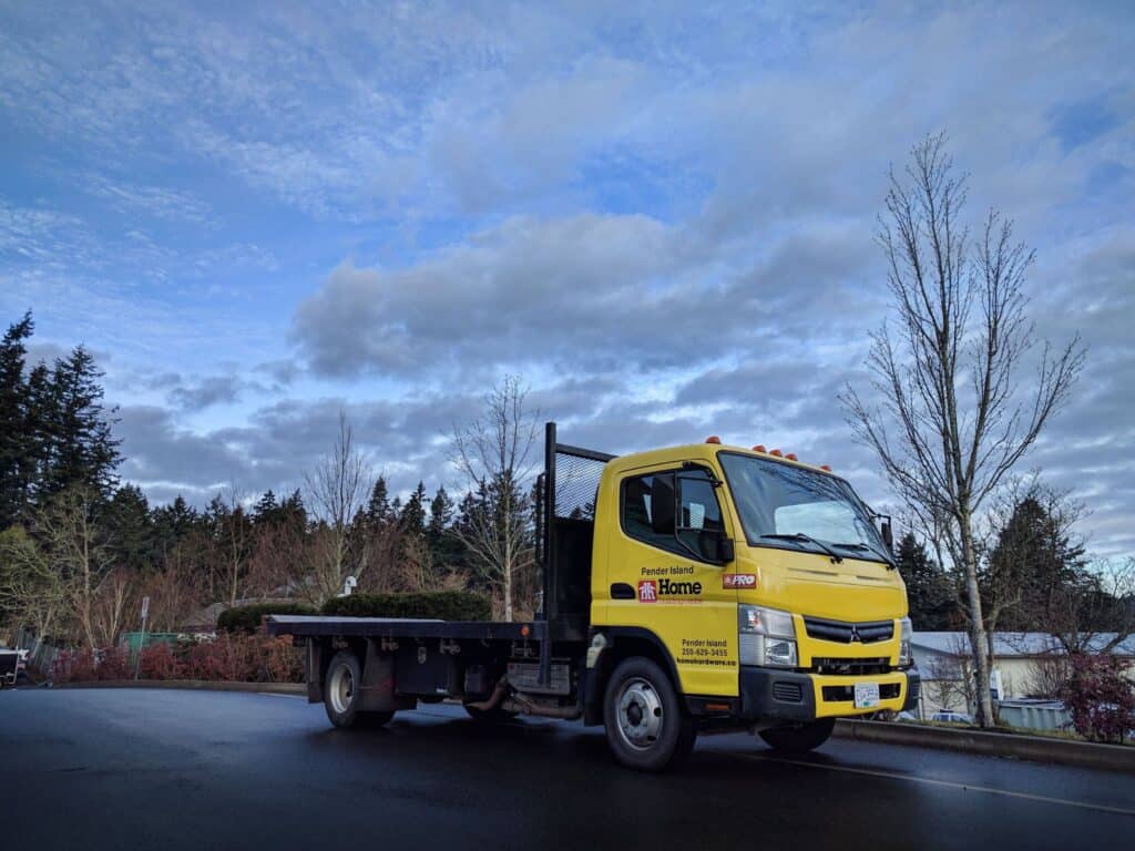 Bright yellow vehicle wrap on a flatbed truck in Victoria, showcasing custom signage.