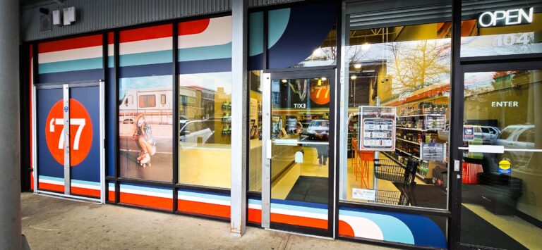 Custom signs and vehicle wraps displayed on a storefront in Victoria, showcasing vibrant colors and.