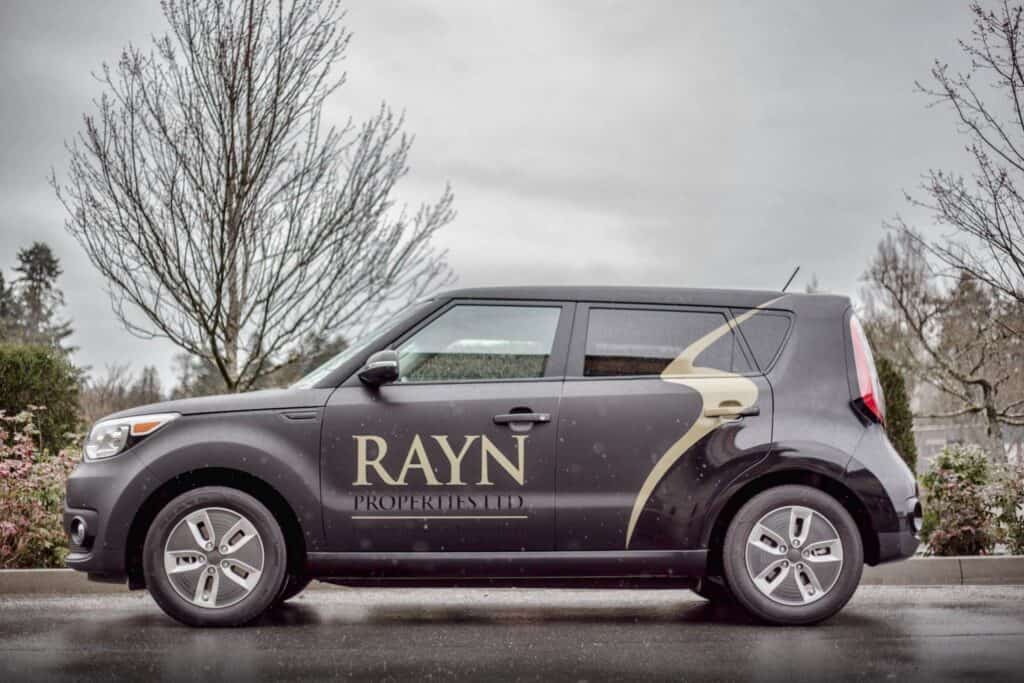 Custom vehicle wrap for RAYN Properties on a compact car.