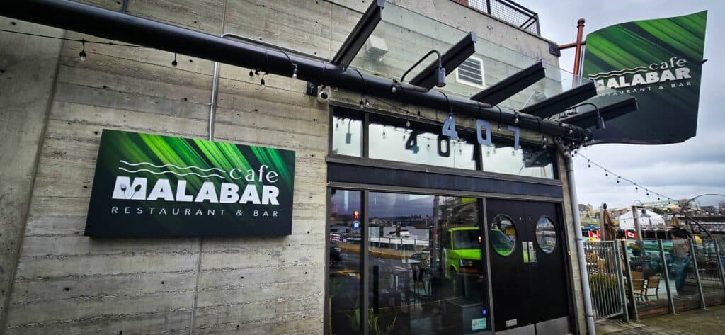 Exterior view of Cafe Malabar with custom signage and entrance in Victoria.