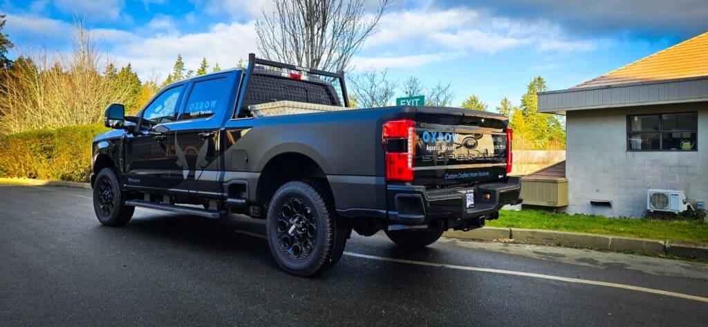 Custom vehicle wrap on a black pickup truck in Victoria, showcasing professional signage.
