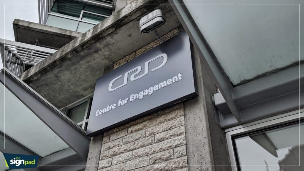 Modern black and white sign for Centre for Engagement on building exterior.