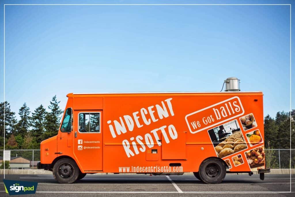 Indecent Risotto food truck with vibrant orange wrap and menu images in Victoria.