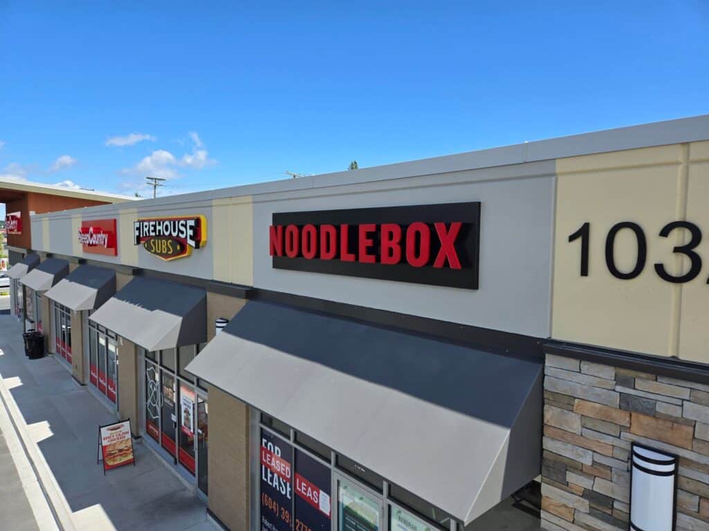 Noodlebox sign on storefront with bold red and black lettering in Victoria, showcasing a popular Asi.