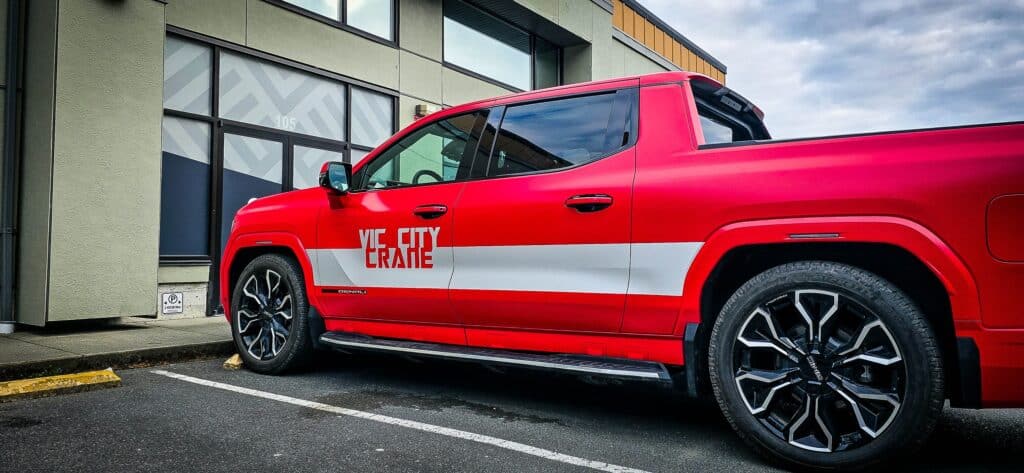 Vehicle wrap on a red pickup truck with "VIC CITY CREATE" branding.