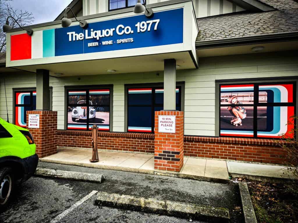 Sign for The Liquor Co. 1977 featuring bold colors and clear branding.