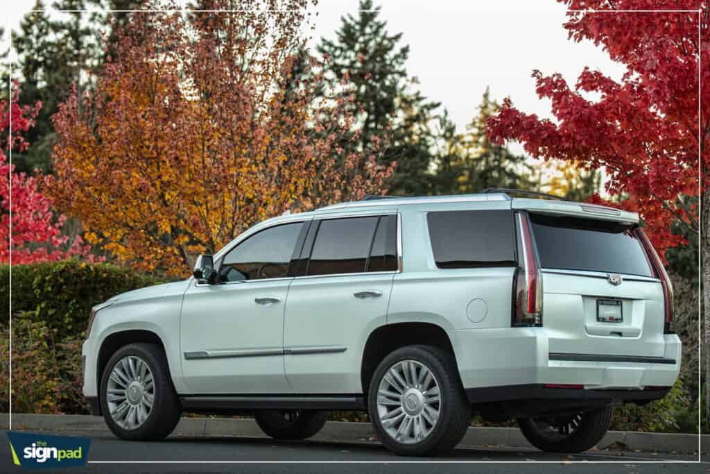 Vehicle wrap advertising on a Cadillac SUV in Victoria, showcasing custom signage and vehicle brandi.