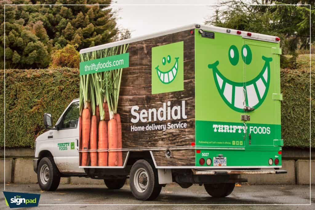 Food delivery truck with bright green smiley face logo and "Sendial" branding.
