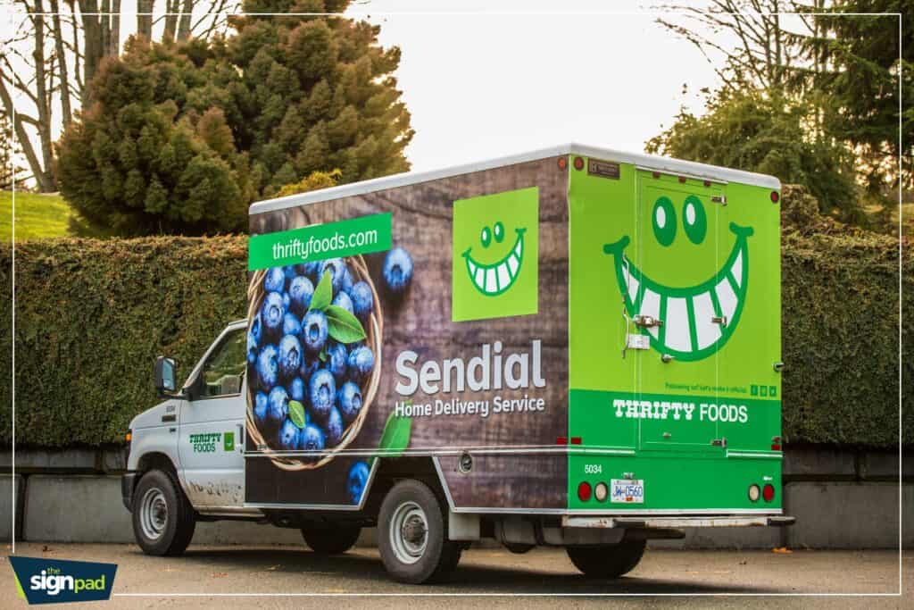 Bright green custom food delivery van with smiley face logo and branding.