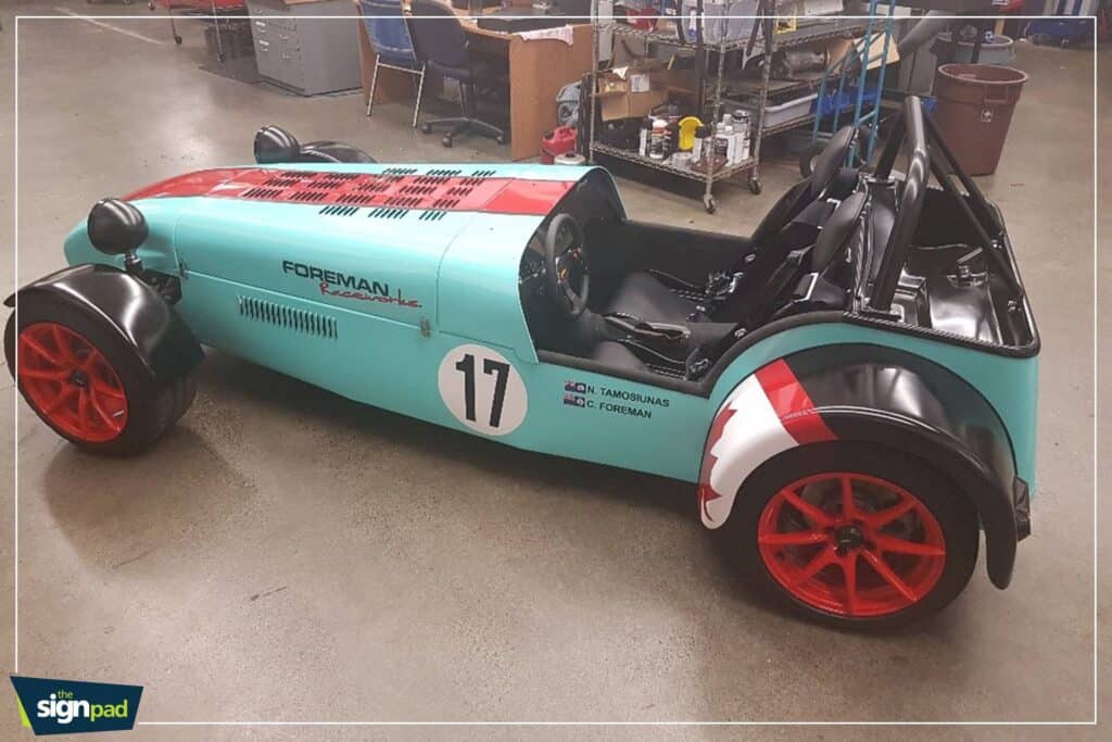 Custom race car with "Forman" branding and red wheels for vehicle wraps Victoria.