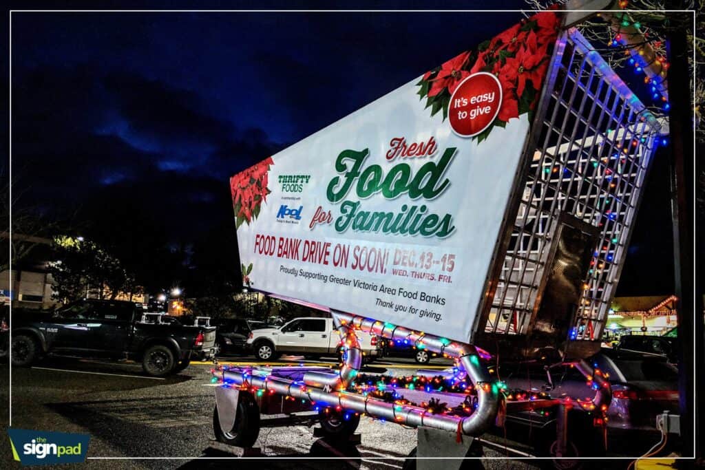 Mobile food bank truck decorated with colorful lights for a community food drive event.
