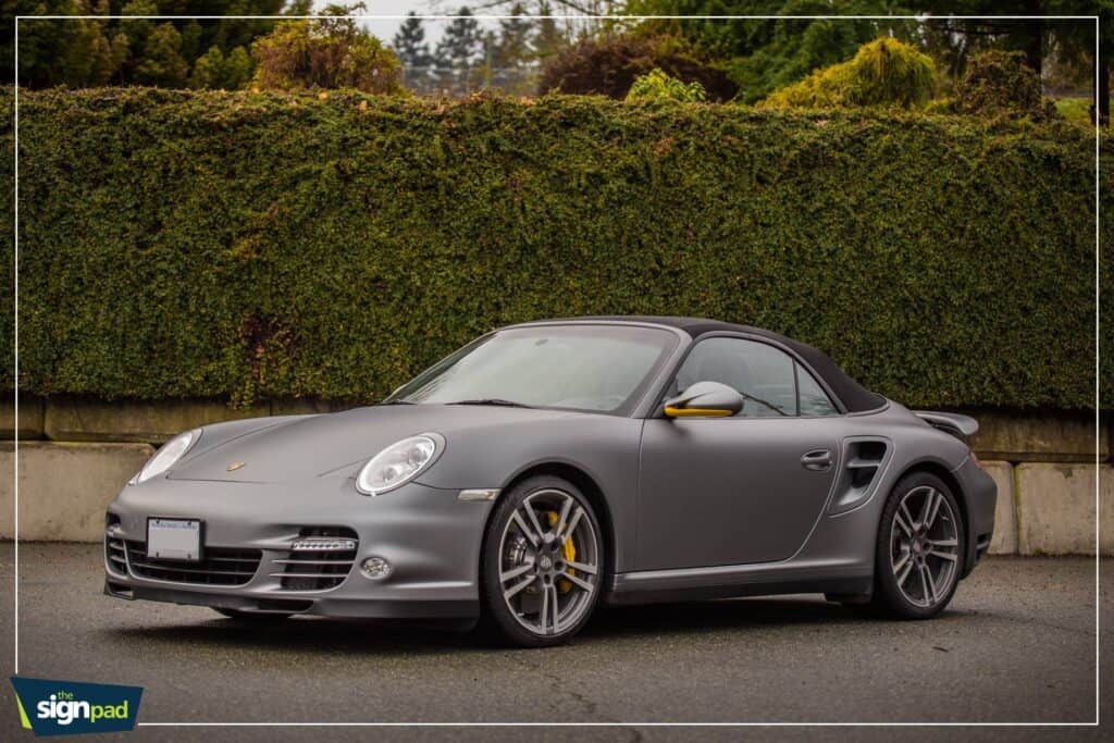 Porsche sports car in matte gray finish with sleek design and stylish wheels.