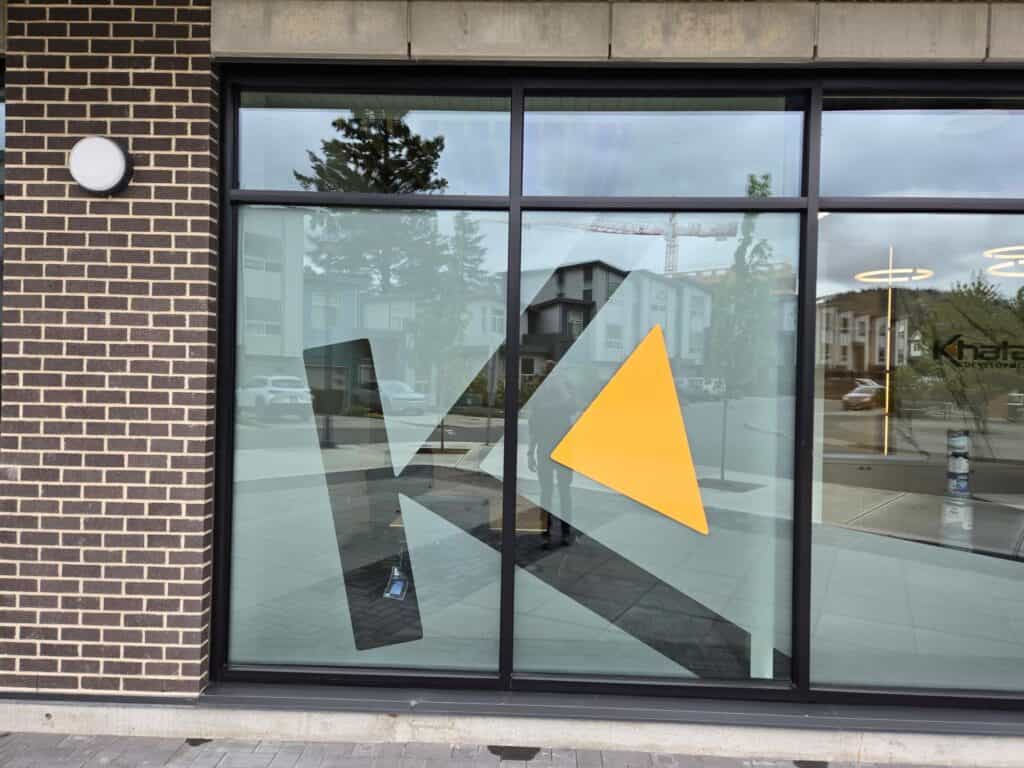 Modern geometric sign design on glass storefront in Victoria.